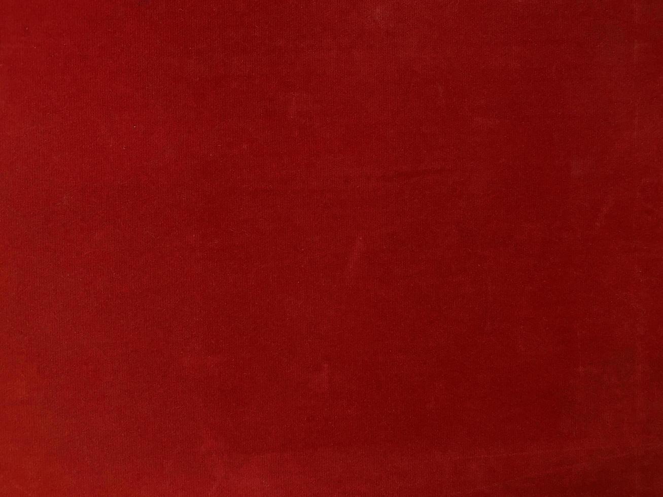 textura de tecido de veludo vermelho usada como plano de fundo. fundo de tecido vermelho vazio de material têxtil macio e liso. há espaço para o texto. foto