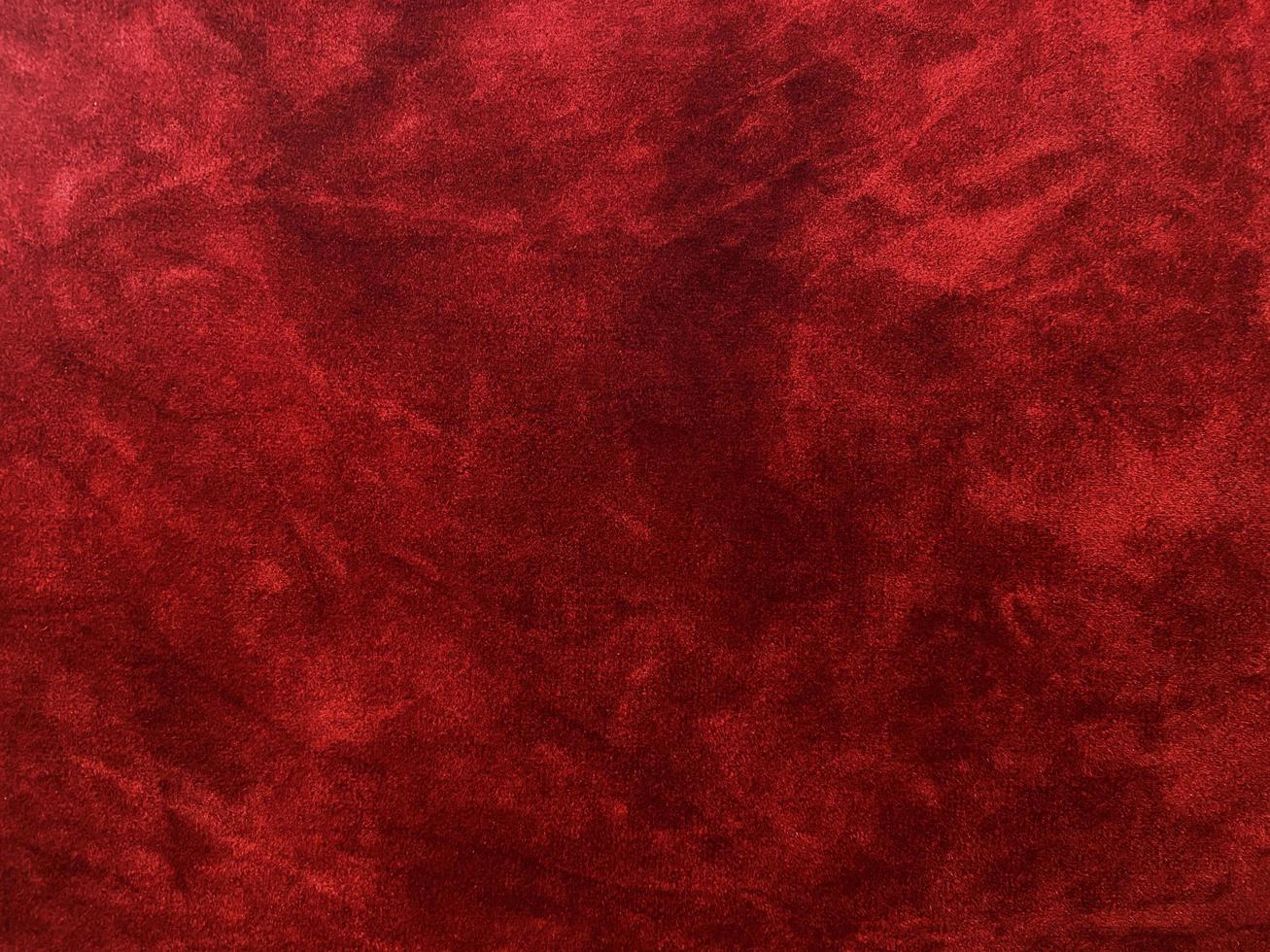 textura de tecido de veludo vermelho escuro usada como plano de fundo. fundo de tecido vermelho escuro vazio de material têxtil macio e liso. há espaço para o texto. foto