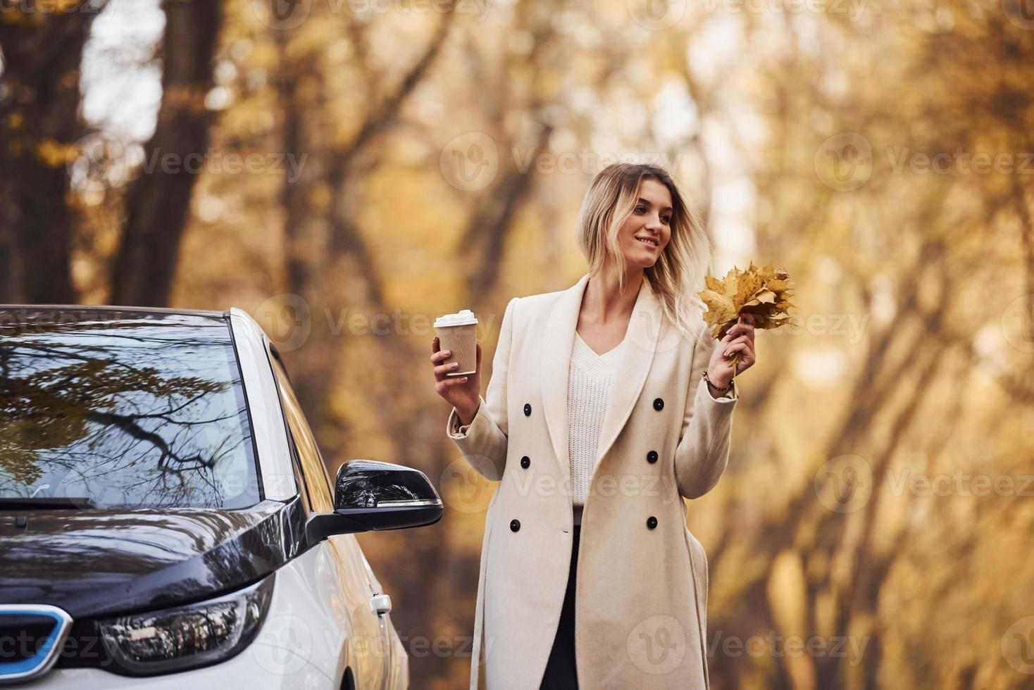 curtindo a natureza. menina tem viagem de outono de carro. automóvel novo e moderno na floresta foto