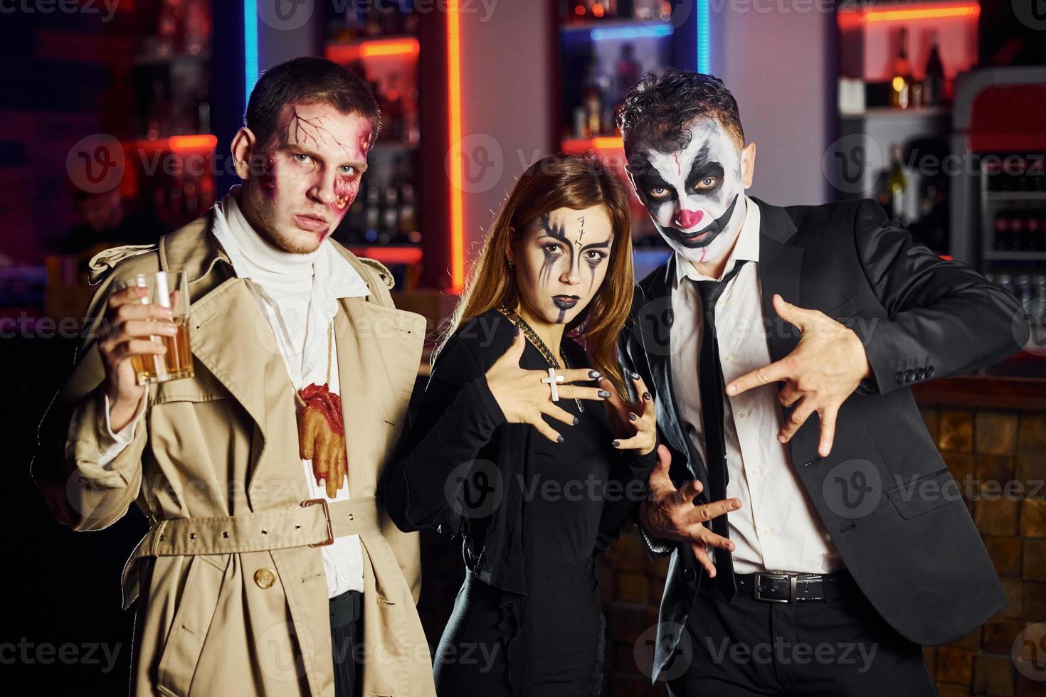 amigos está na festa temática de halloween em maquiagem assustadora e fantasias se divertem e posam para a câmera juntos foto