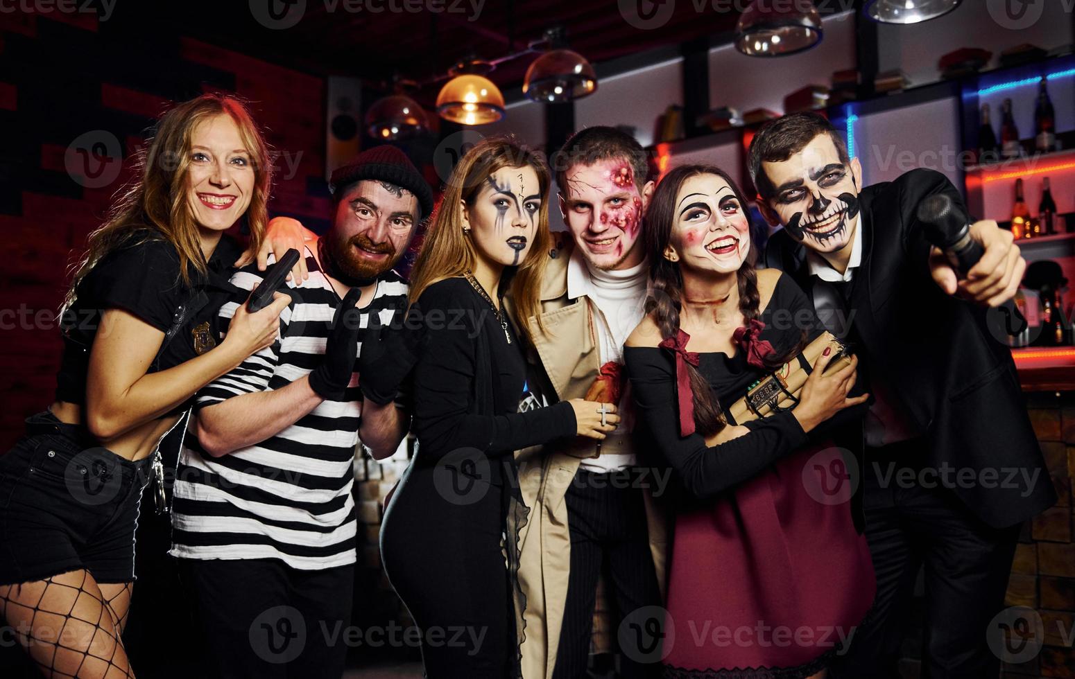 amigos está na festa temática de halloween em maquiagem assustadora e fantasias se divertem e posam para a câmera juntos foto