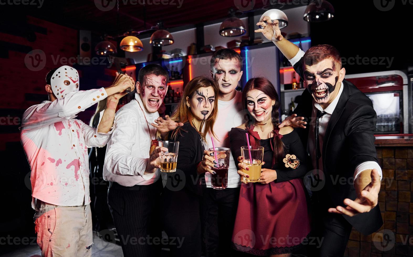 posando para a câmera. amigos está na festa temática de halloween em maquiagem e fantasias assustadoras foto