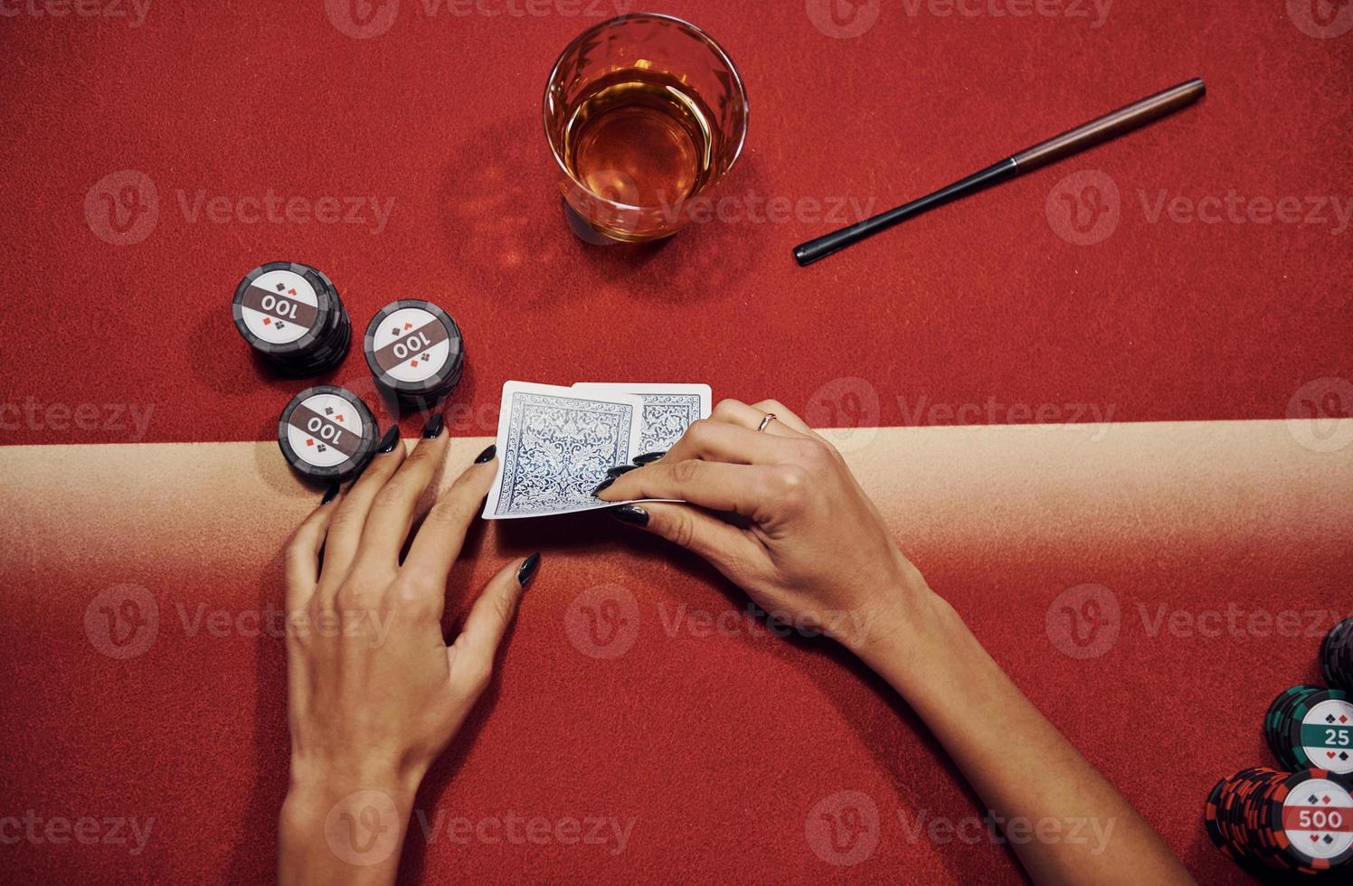 vista superior das mãos da mulher. menina joga pôquer por mesa no cassino foto