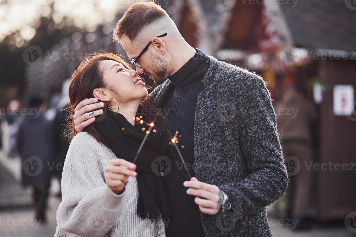 com estrelinhas nas mãos. feliz casal multirracial juntos ao ar livre na cidade foto