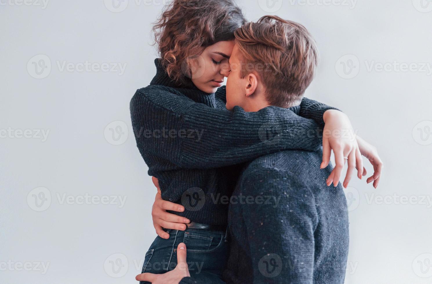 casal jovem bonito se abraçando dentro de casa no estúdio foto