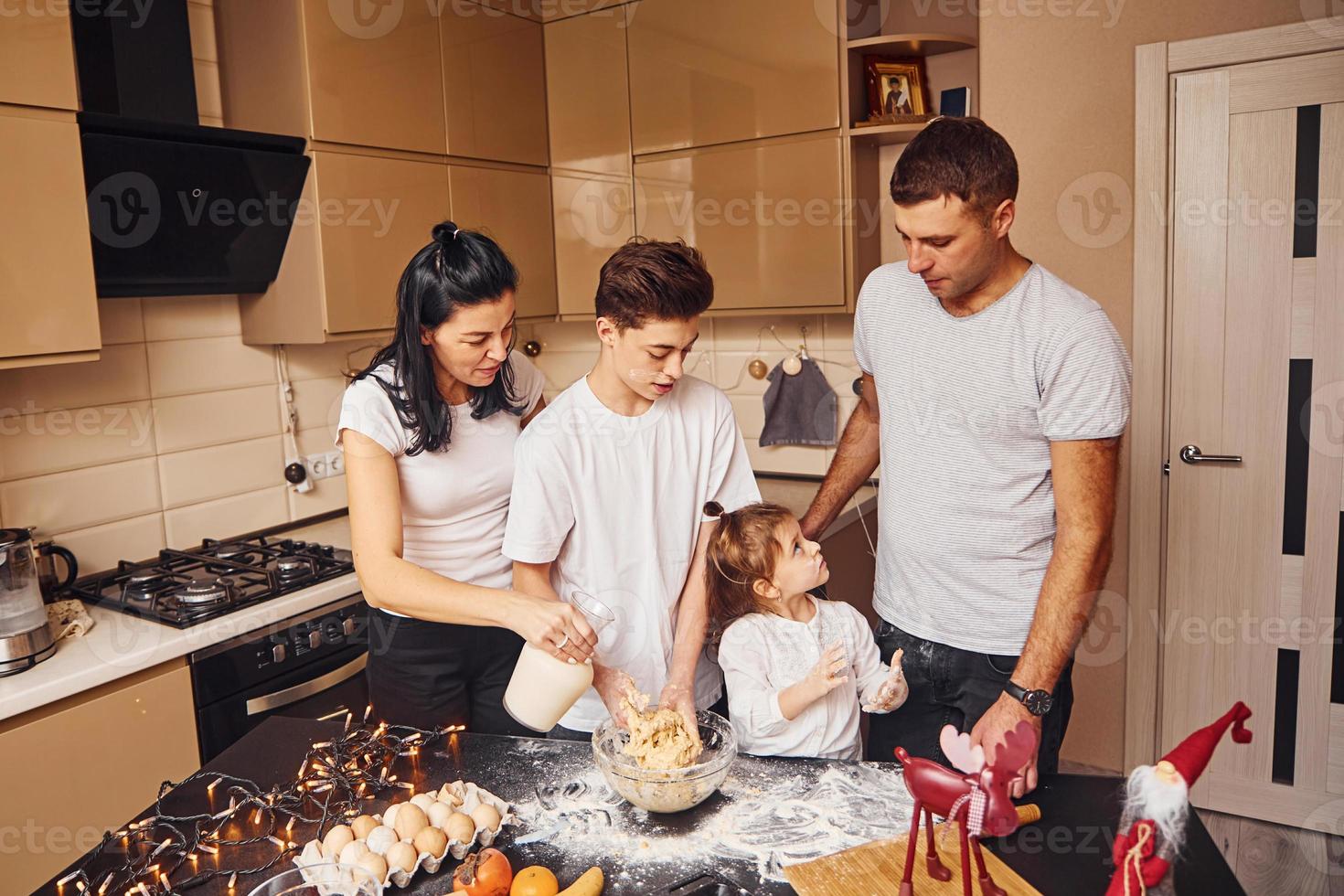 família feliz se diverte na cozinha e preparando comida foto