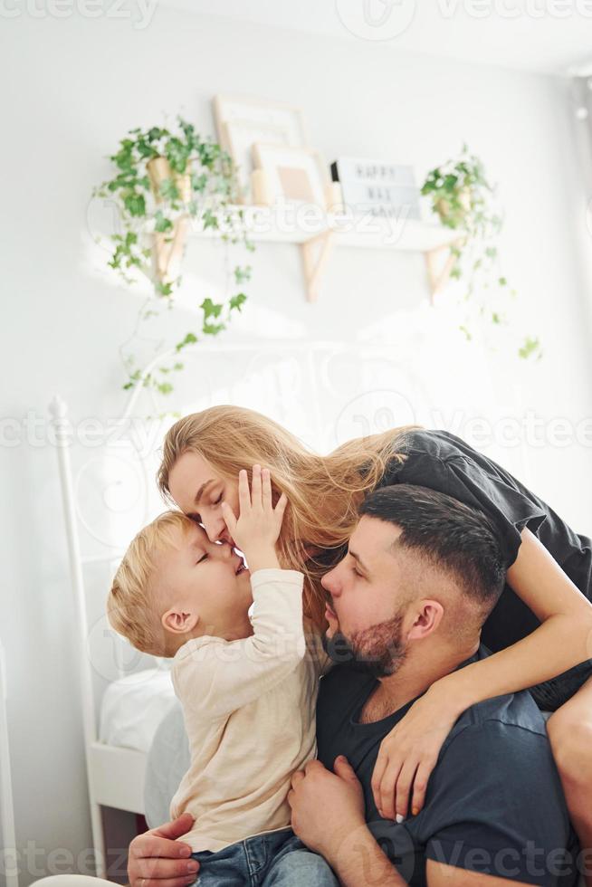 jovem casal com seu filho tem lazer juntos no quarto durante o dia foto