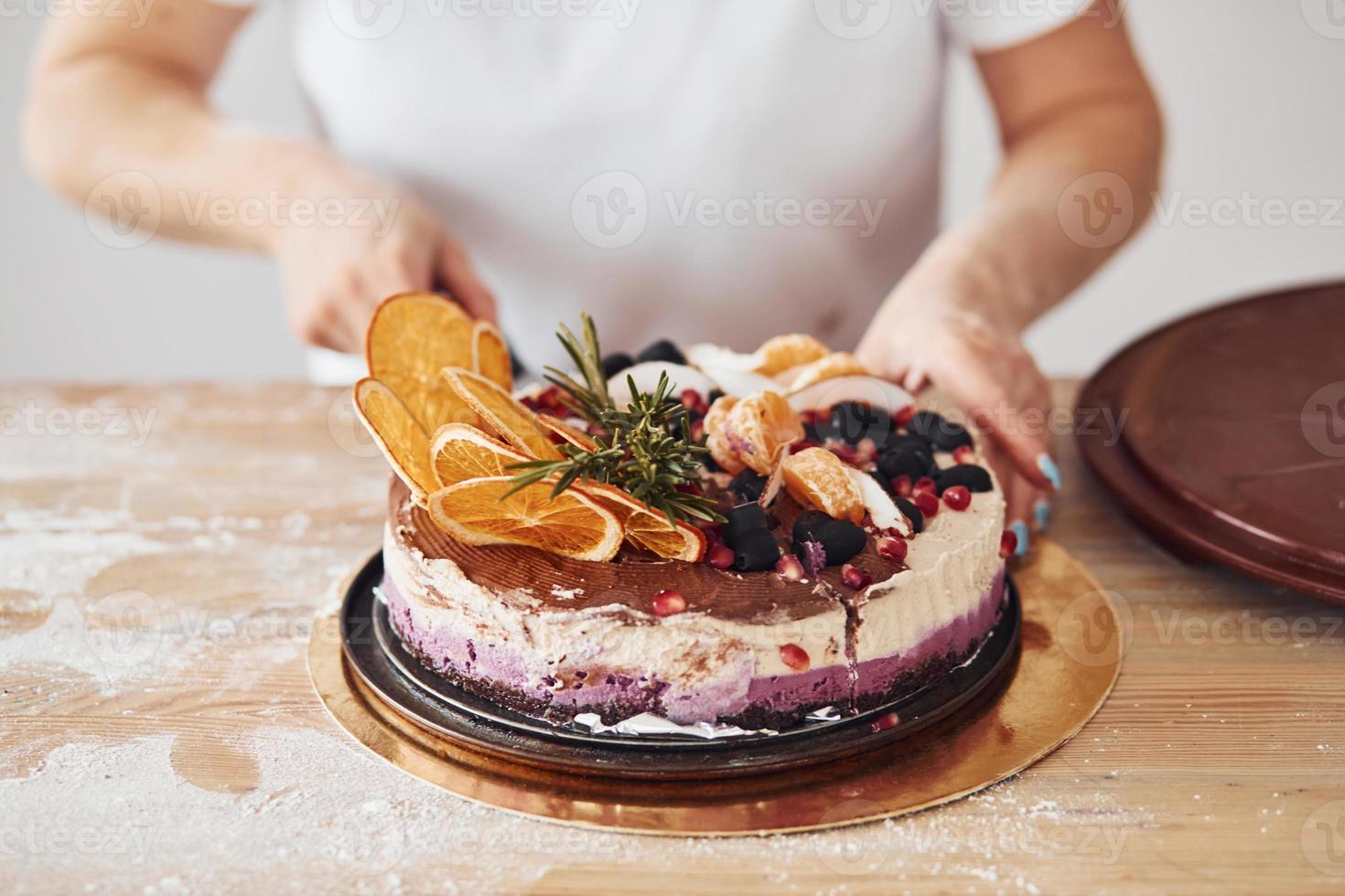 close-up vista da mulher com bolo dietético fresco na cozinha foto