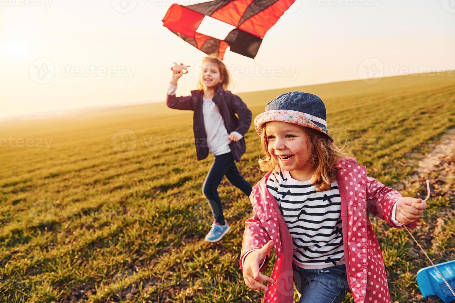 duas amigas se divertem juntas com pipa e carro de brinquedo no campo durante o dia ensolarado foto