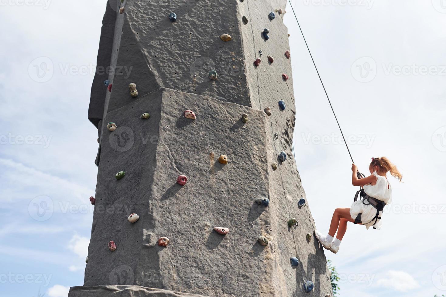 menina em roupas brancas casuais treinando escalada ao ar livre foto