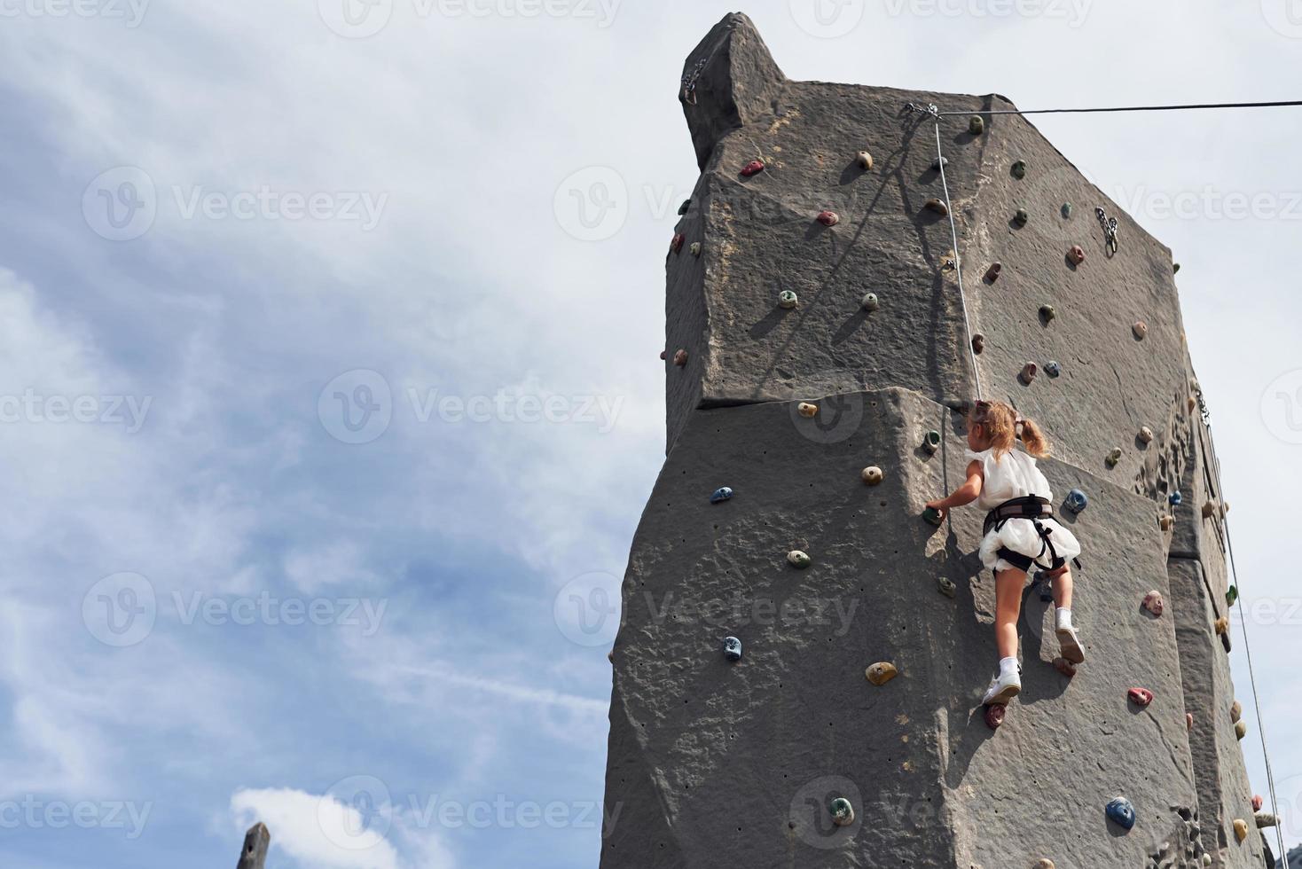 menina em roupas brancas casuais treinando escalada ao ar livre foto