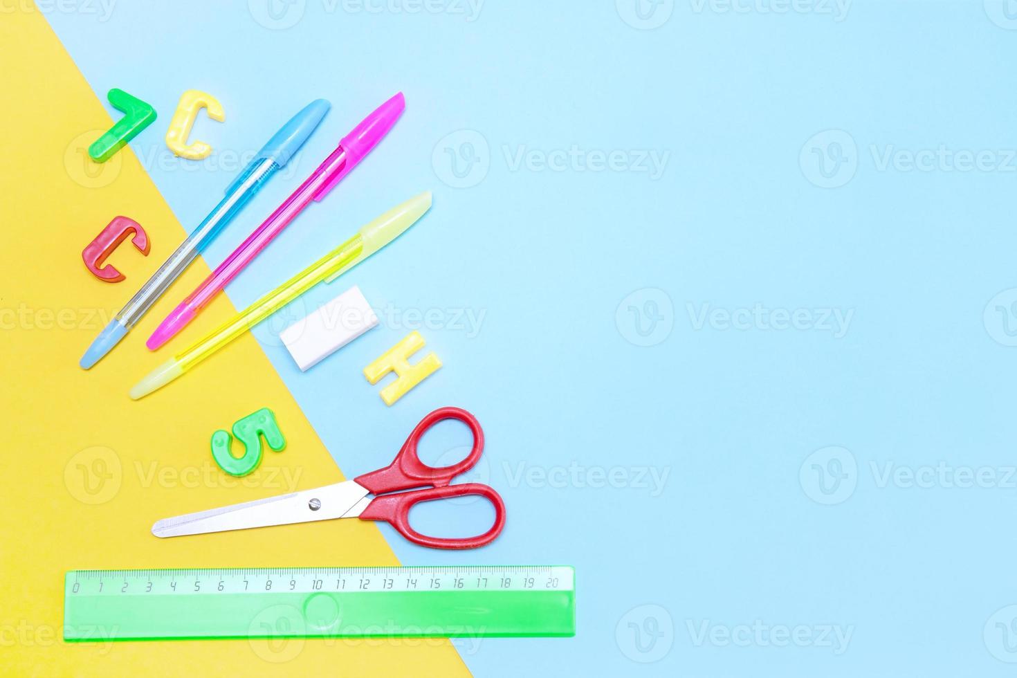 artigos de papelaria escolar - tesoura, canetas, régua em fundo amarelo-azul com fundo de espaço de cópia, de volta à escola foto