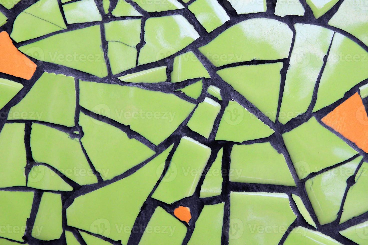 uma parede de peças de cerâmica de cor verde e laranja para segundo plano. foto