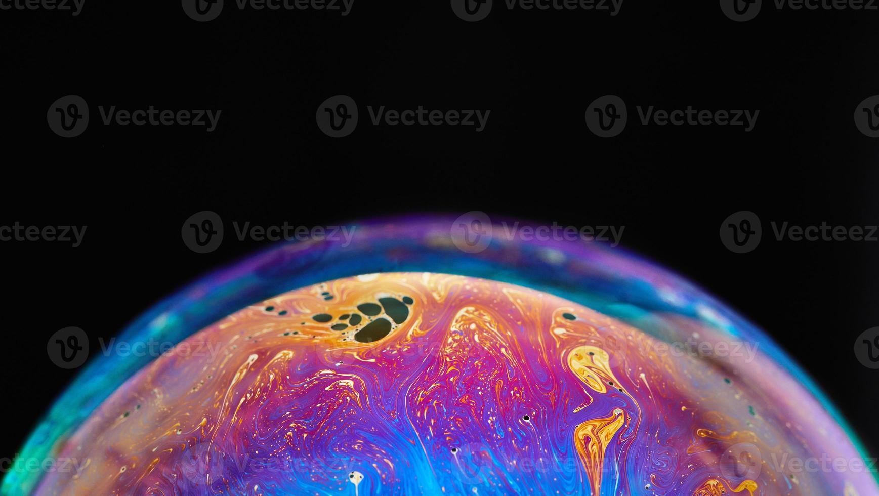 espaço de realidade virtual com planeta psicodélico multicolor abstrato. bolha de sabão closeup como um planeta alienígena em fundo preto foto