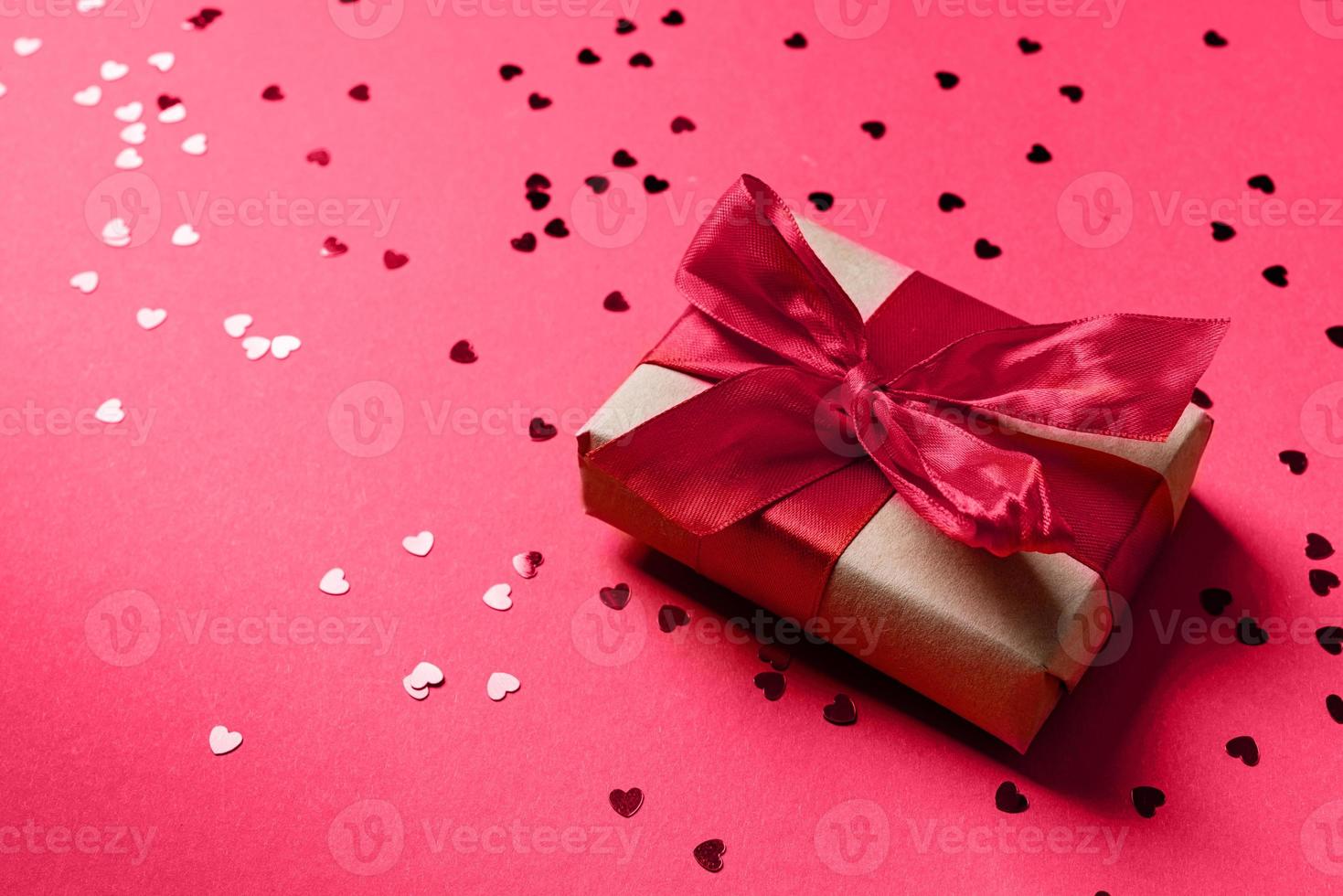 caixa de presente vermelha com uma fita para dia dos namorados comemorando em fundo magenta viva com espaço de cópia foto