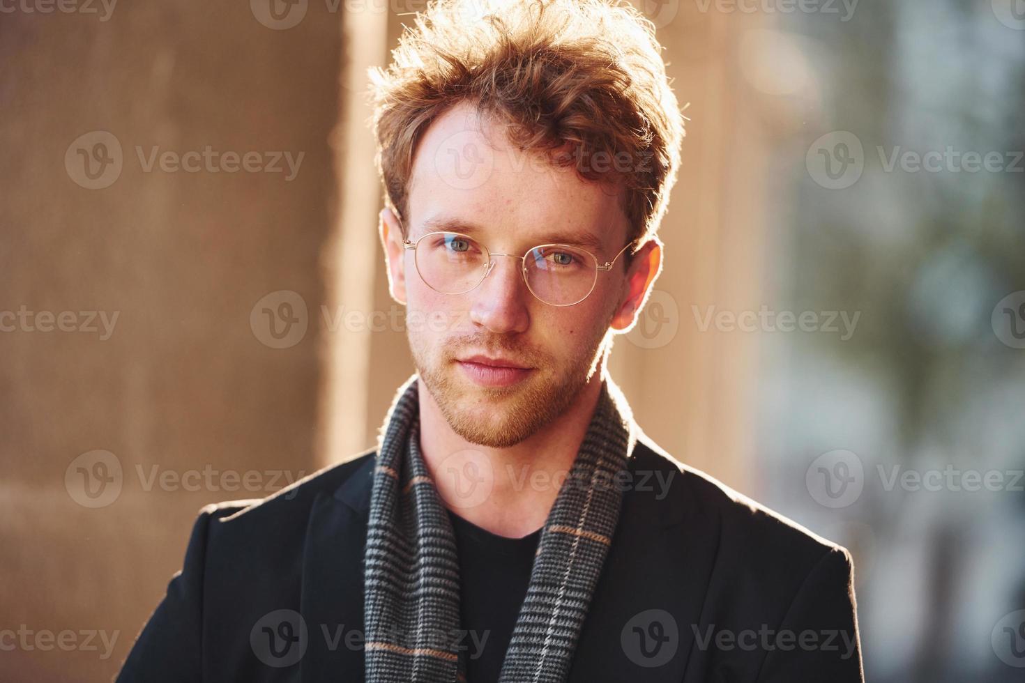 retrato de jovem elegante em óculos e roupas elegantes formais ao ar livre na cidade foto