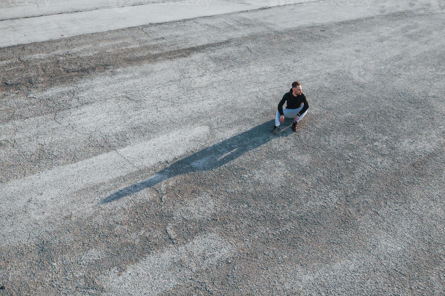 visão superior do homem sentado na estrada à noite sozinho foto