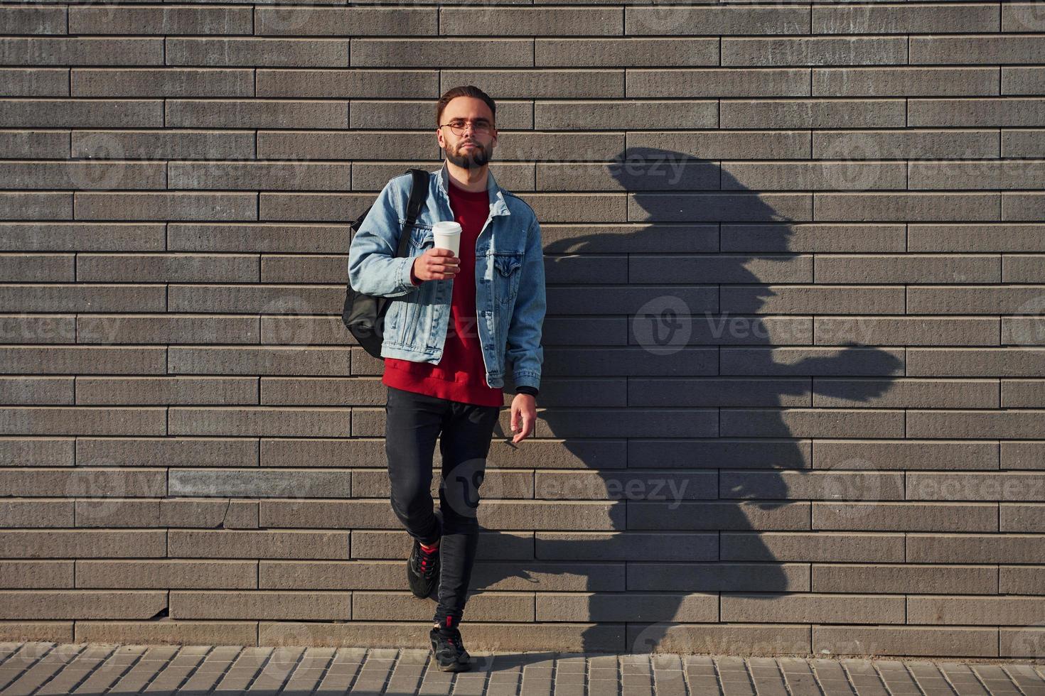 cara jovem bonito em roupas casuais está ao ar livre durante o dia ensolarado foto