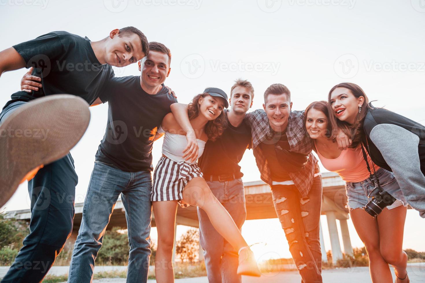 posando para uma câmera. grupo de jovens amigos alegres se divertindo juntos. festa ao ar livre foto