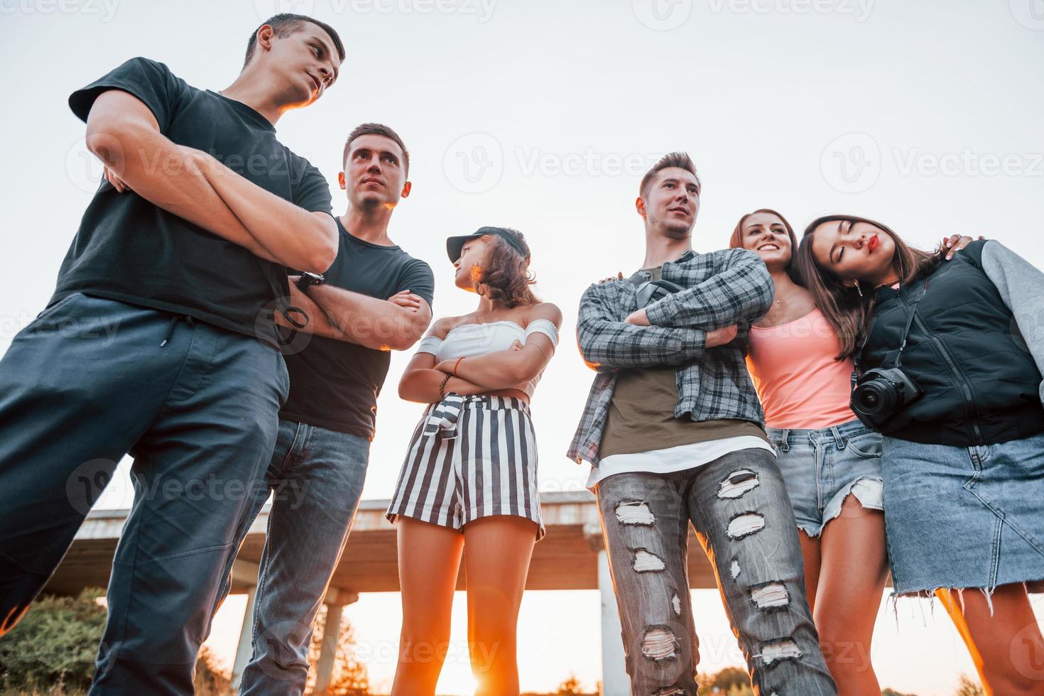 posando para uma câmera. grupo de jovens amigos alegres se divertindo juntos. festa ao ar livre foto