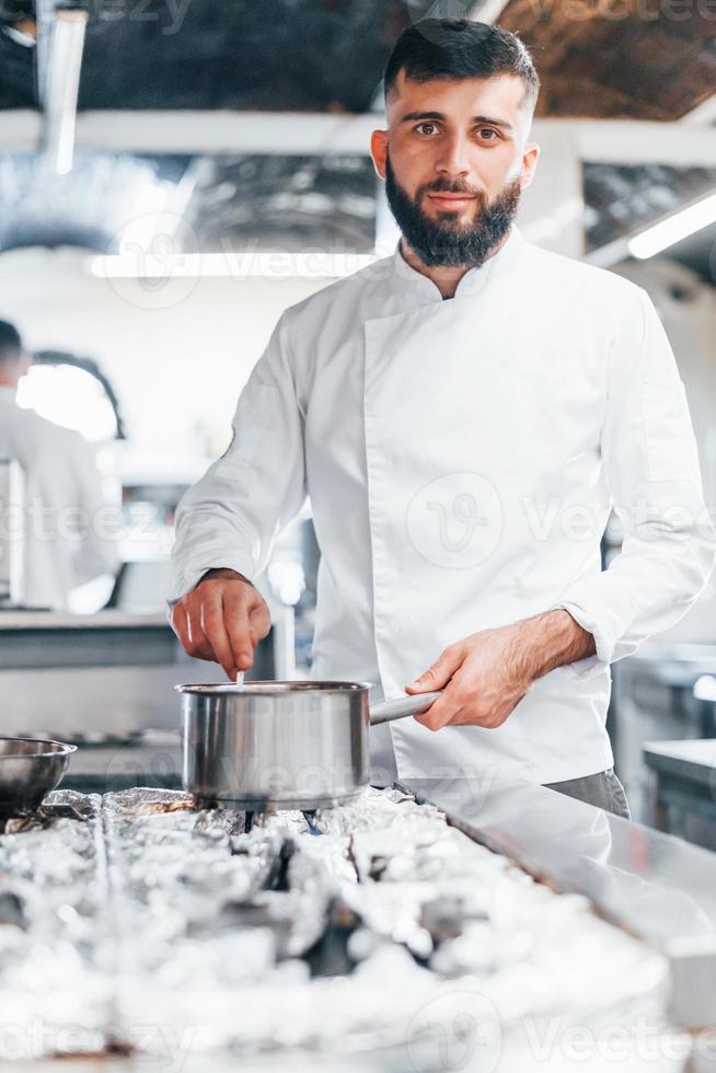 cozinha sopa deliciosa. chef de uniforme branco cozinhando comida na cozinha. dia ocupado no trabalho foto