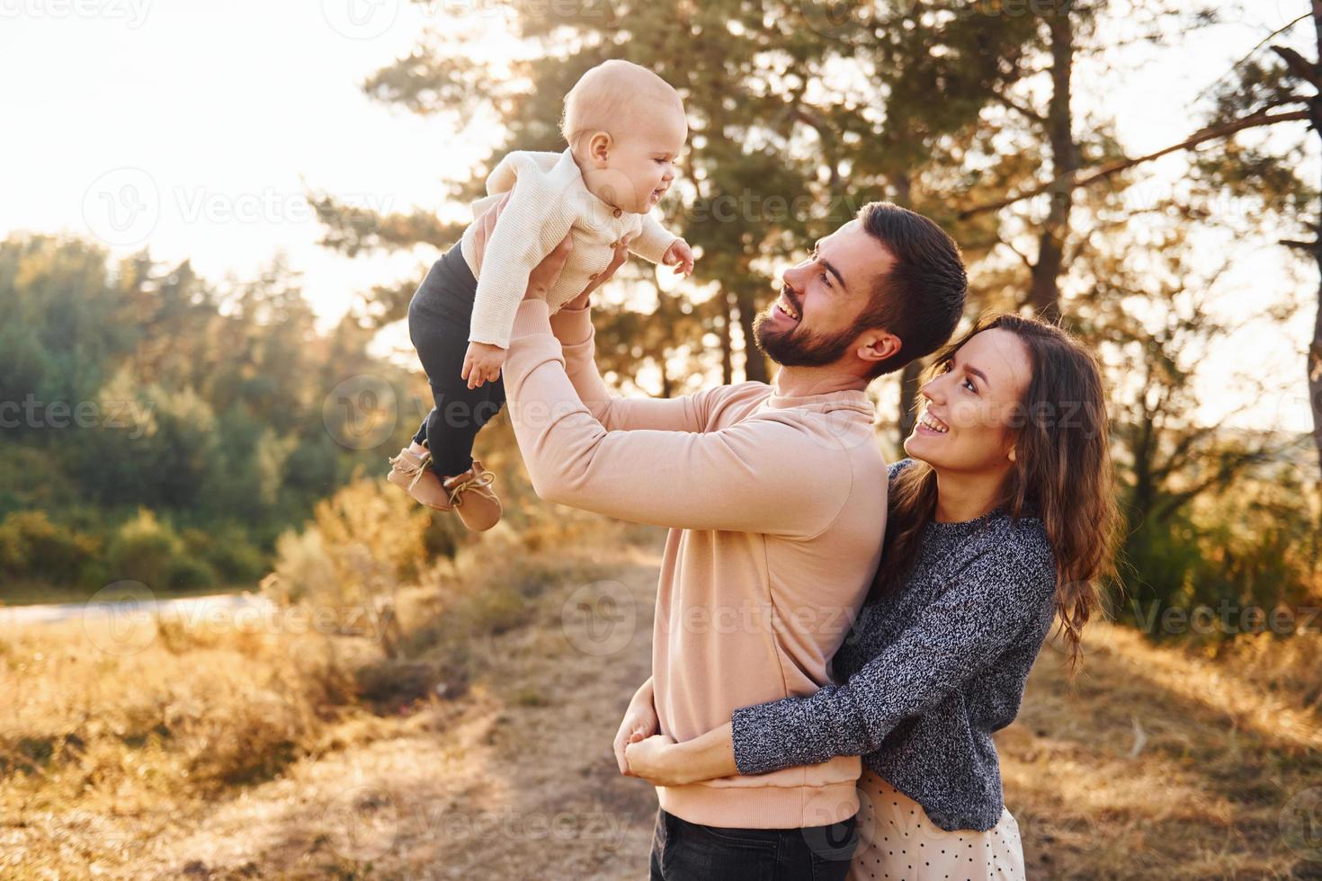 família feliz de mãe, família e bebê descansa ao ar livre. bela natureza ensolarada de outono foto