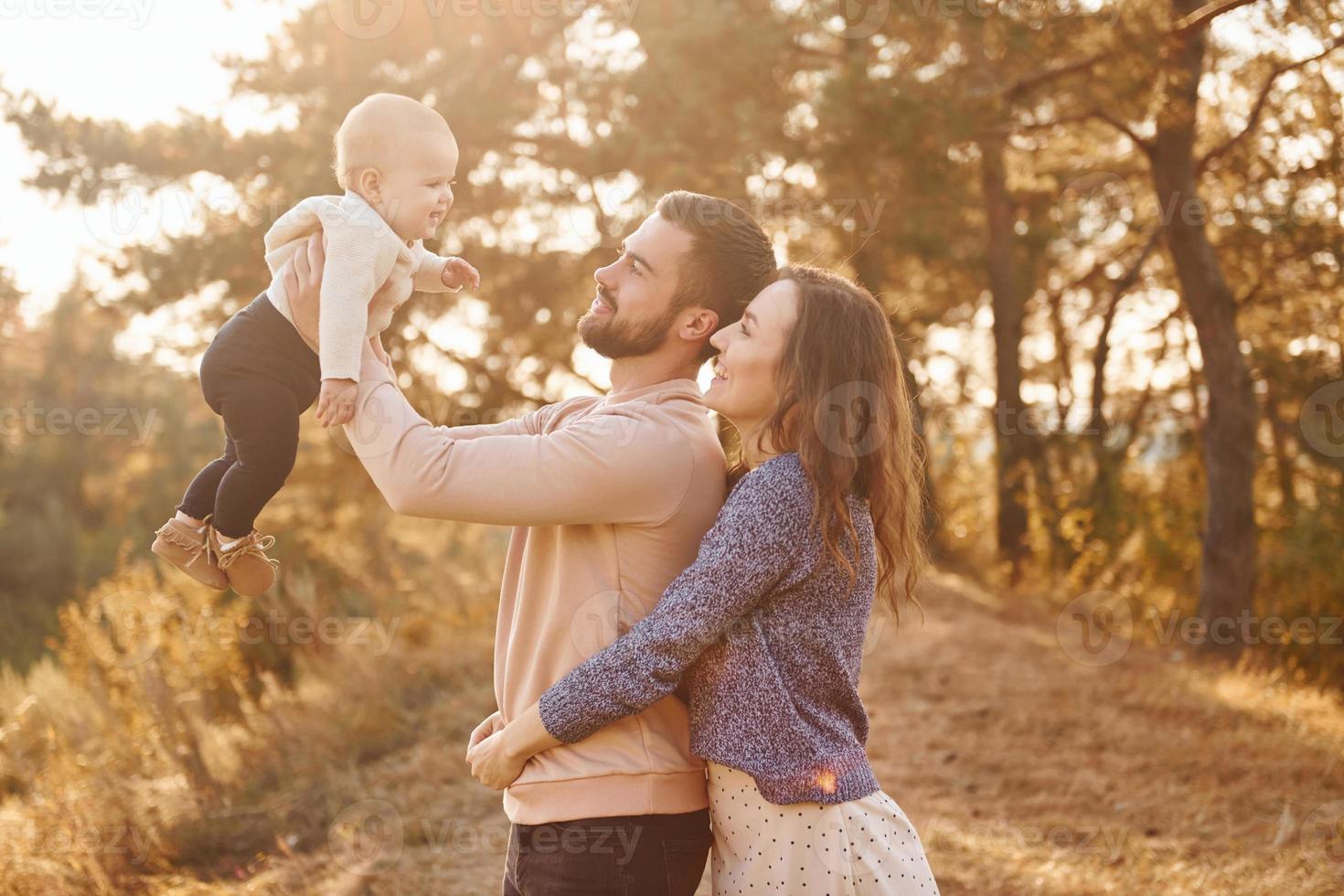 família feliz de mãe, família e bebê descansa ao ar livre. bela natureza ensolarada de outono foto