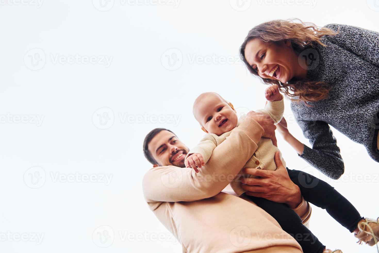 vista de baixo. família feliz de mãe, família e bebê descansa ao ar livre. bela natureza ensolarada de outono foto