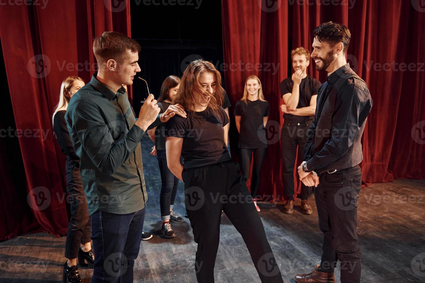 prática de contato visual. grupo de atores em roupas de cor escura no ensaio no teatro foto