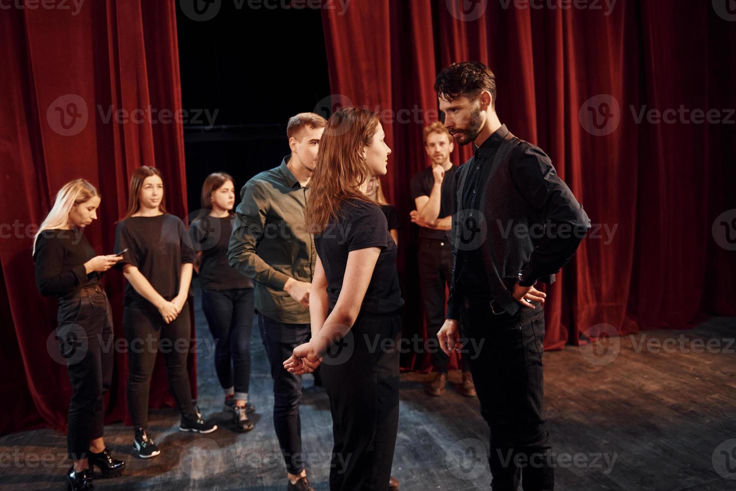 prática de contato visual. grupo de atores em roupas de cor escura no ensaio no teatro foto