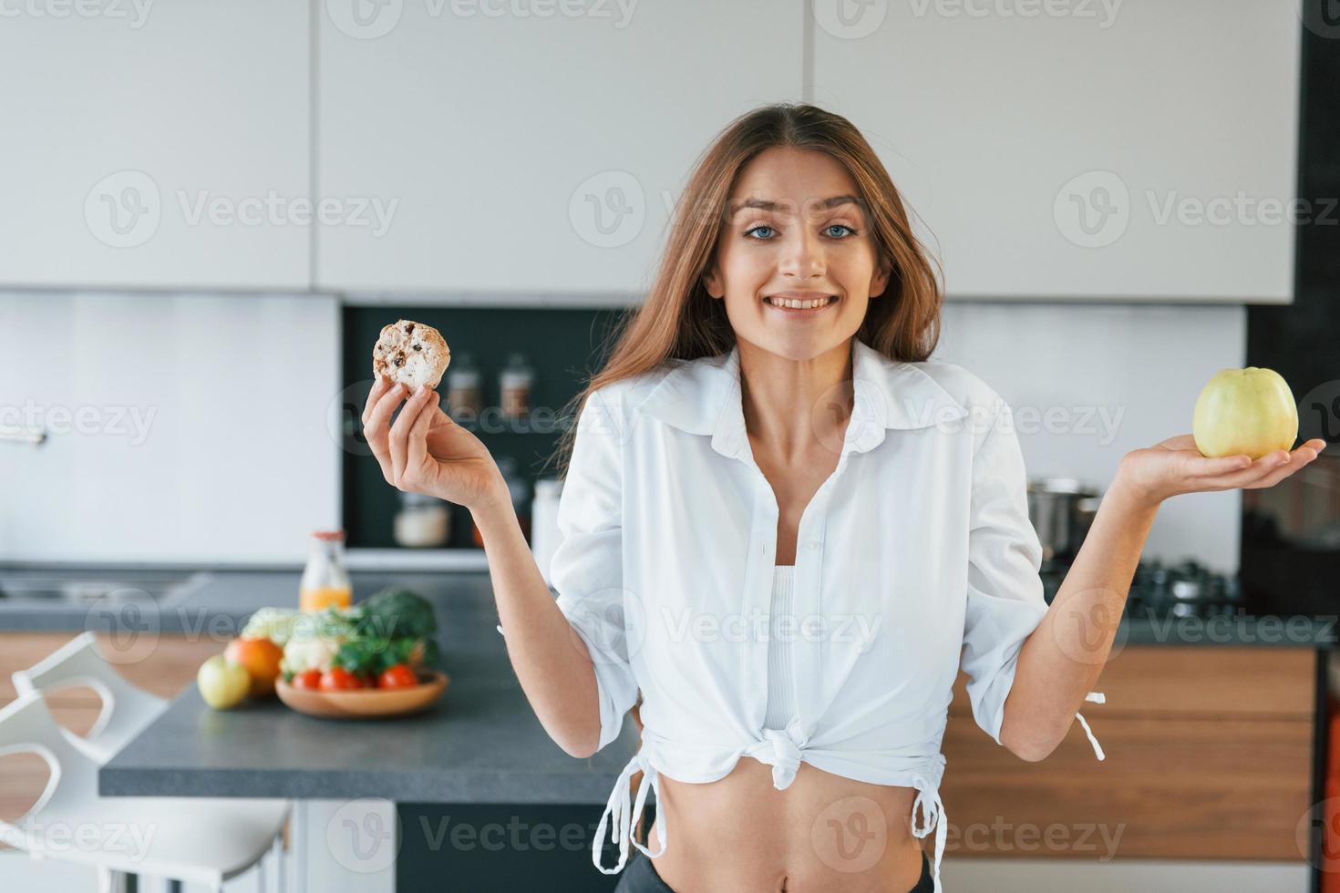 jovem europeia está dentro de casa na cozinha dentro de casa com comida saudável foto