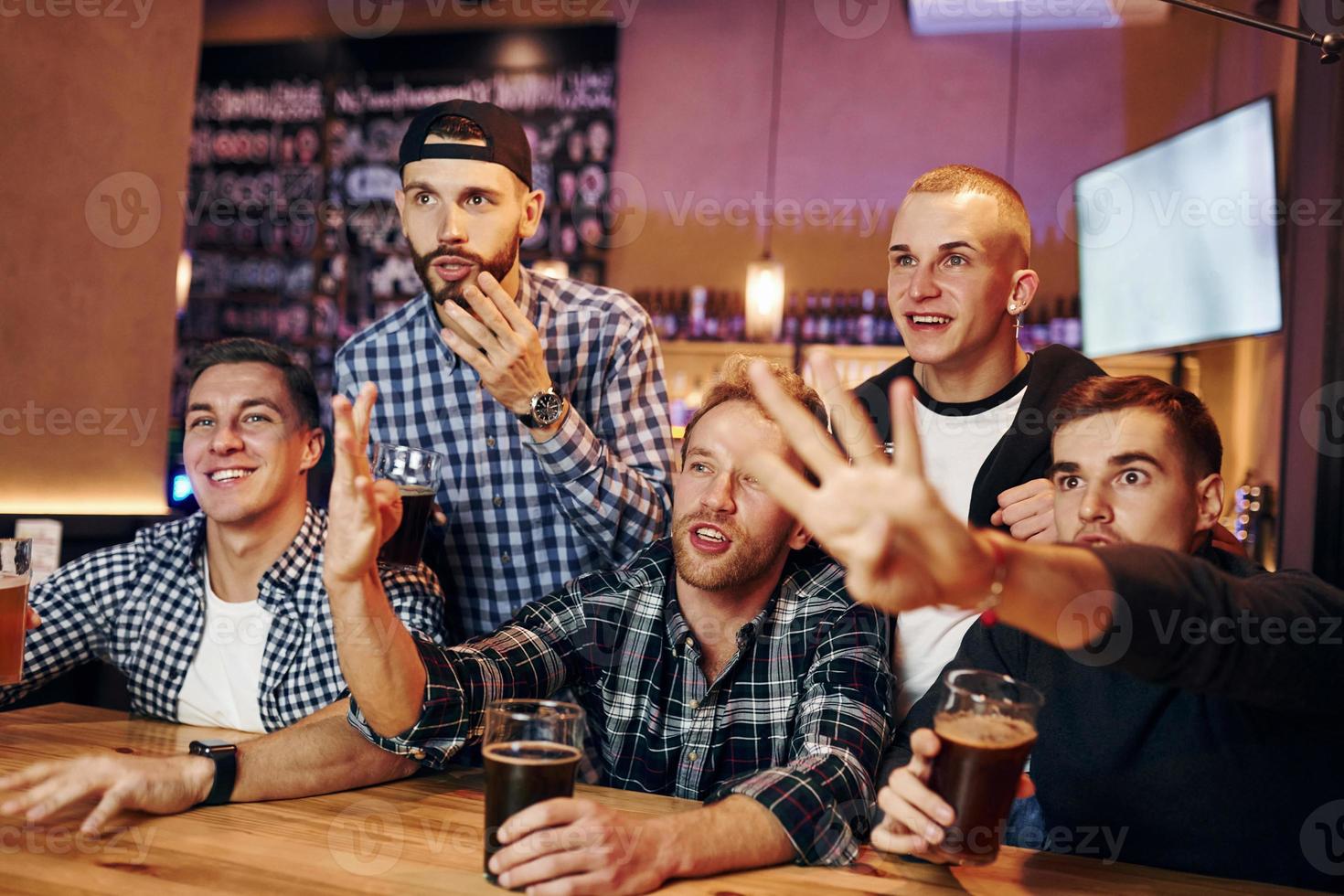 fãs de futebol assistindo tv. grupo de pessoas juntas dentro de casa no pub se divertem no fim de semana foto