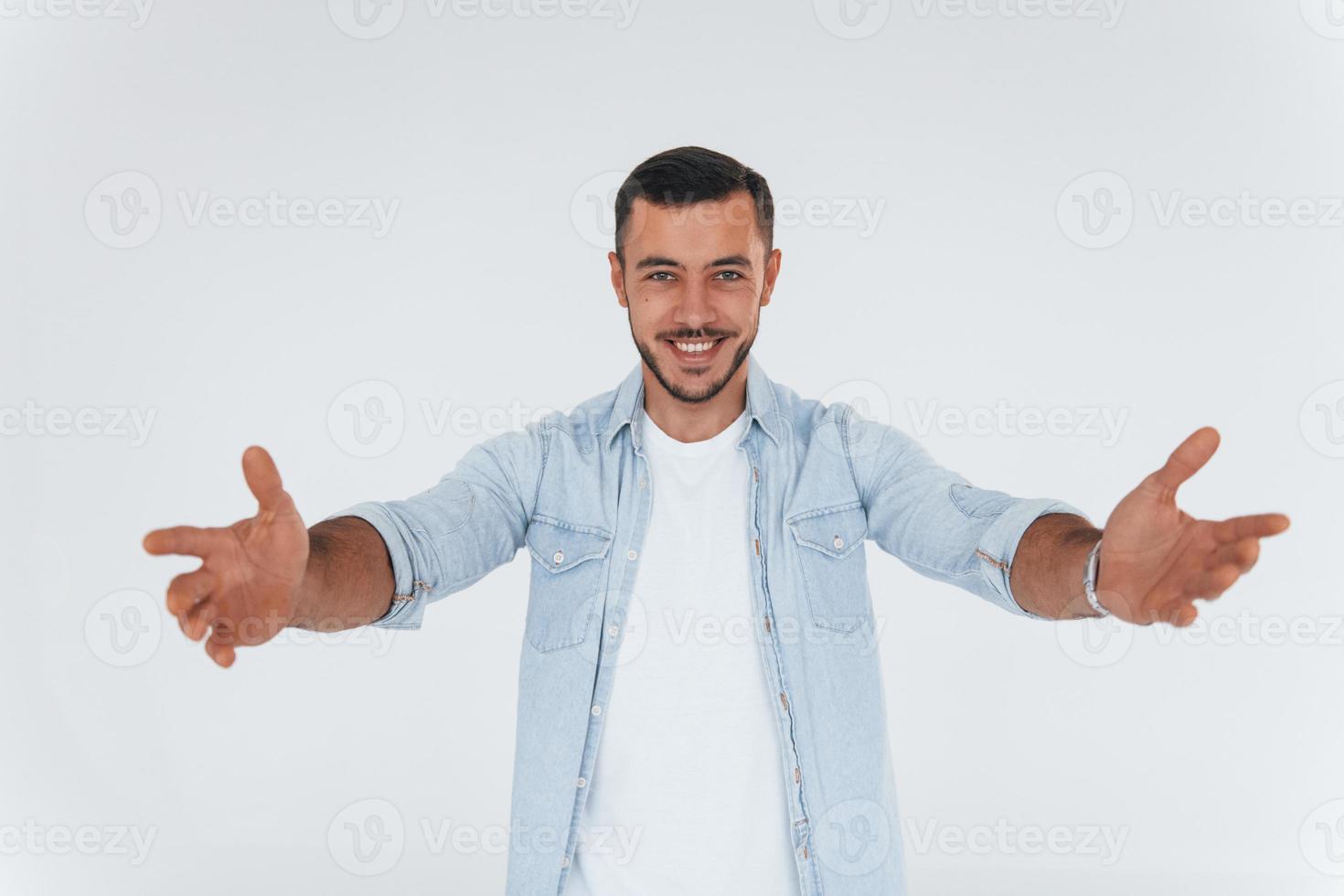 jovem bonito em pé dentro de casa contra um fundo branco foto