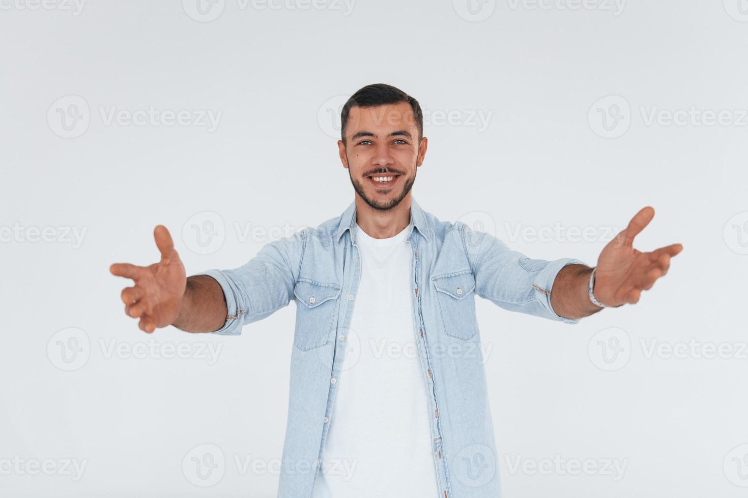 jovem bonito em pé dentro de casa contra um fundo branco foto