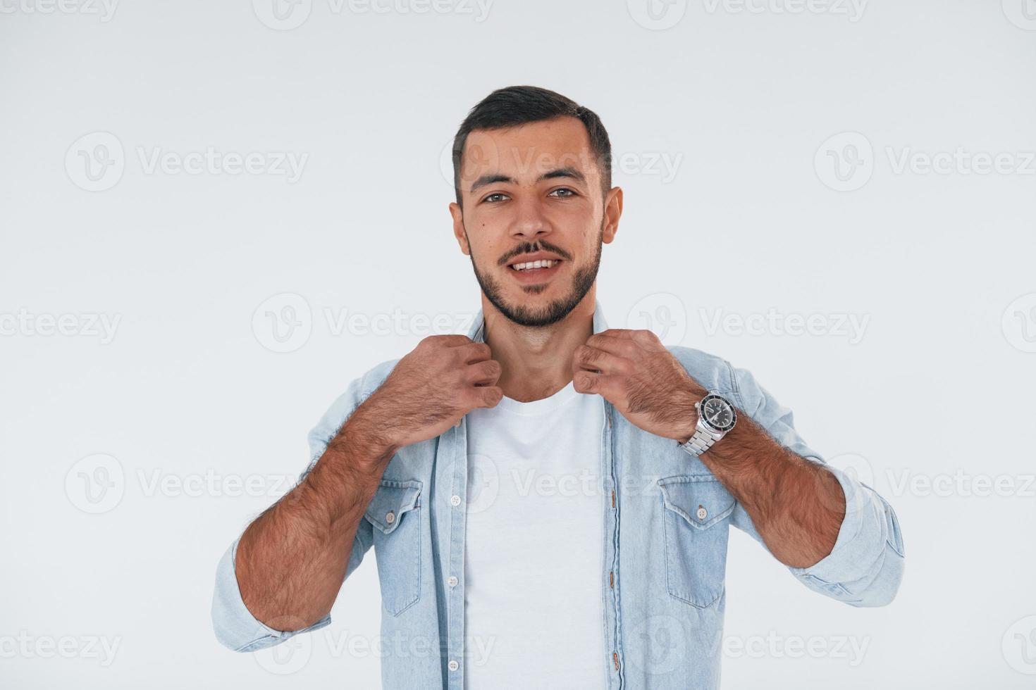 jovem elegante em pé dentro de casa contra um fundo branco foto