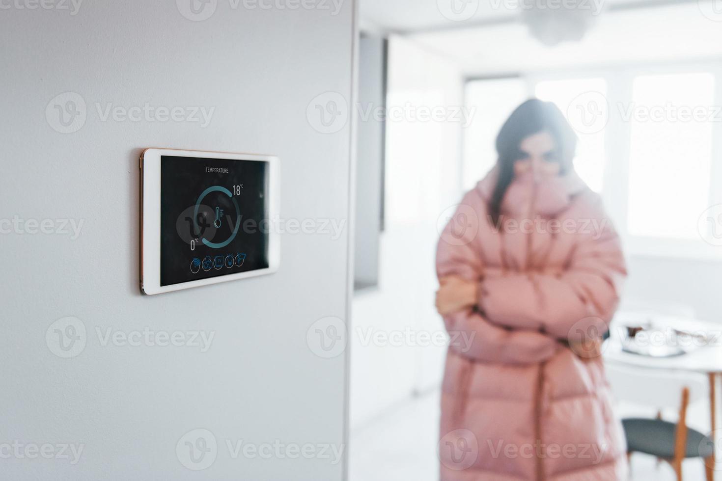 problema com temperatura. mulher está dentro de casa controlando tecnologia de casa inteligente foto