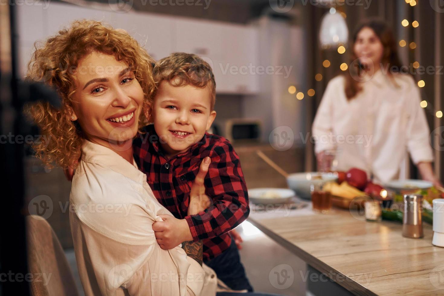 passar o fim de semana juntos. família feliz de mãe, filha e filho está na cozinha à noite foto