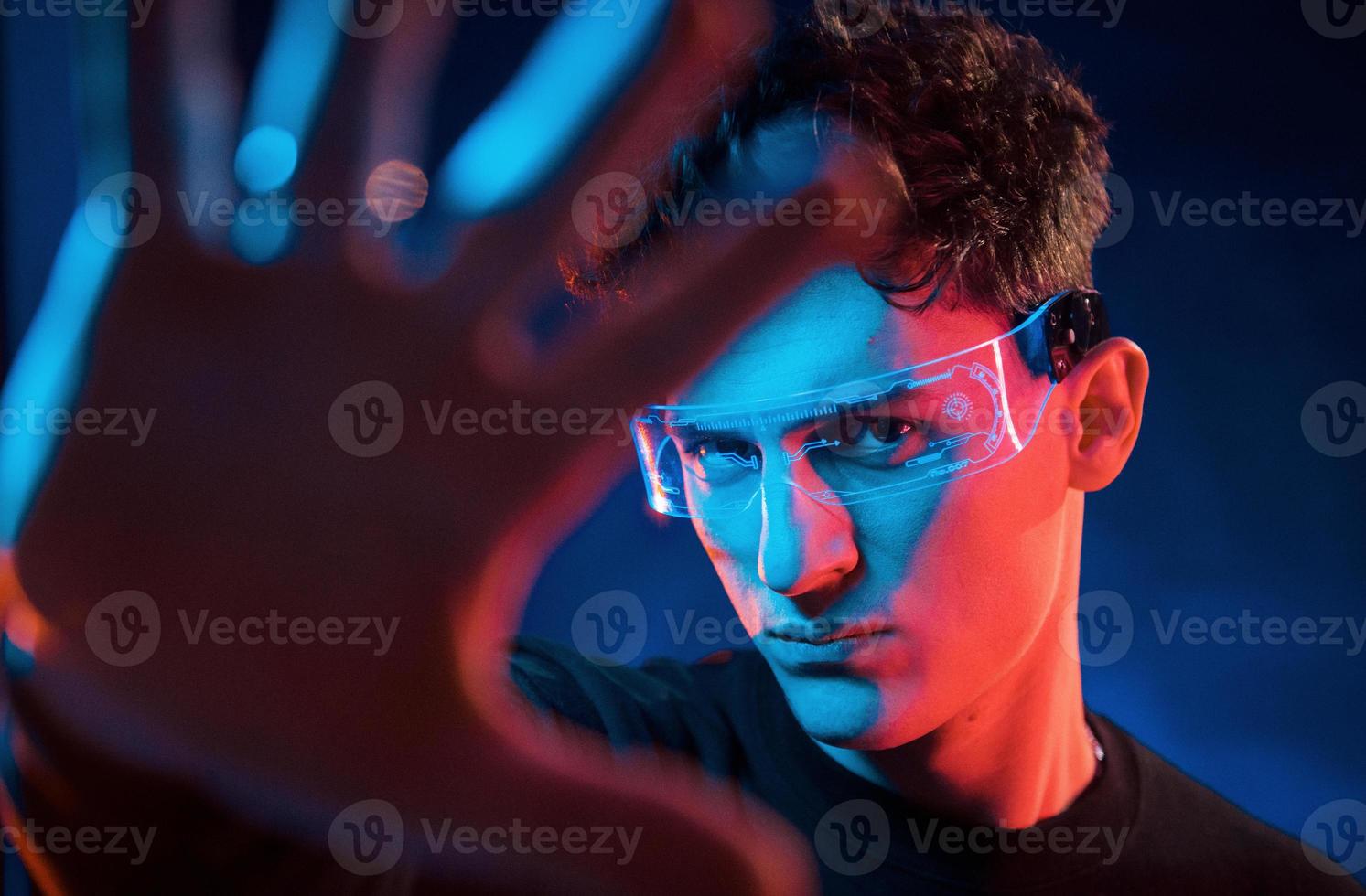 fechar retrato. iluminação neon. jovem europeu está no estúdio escuro foto