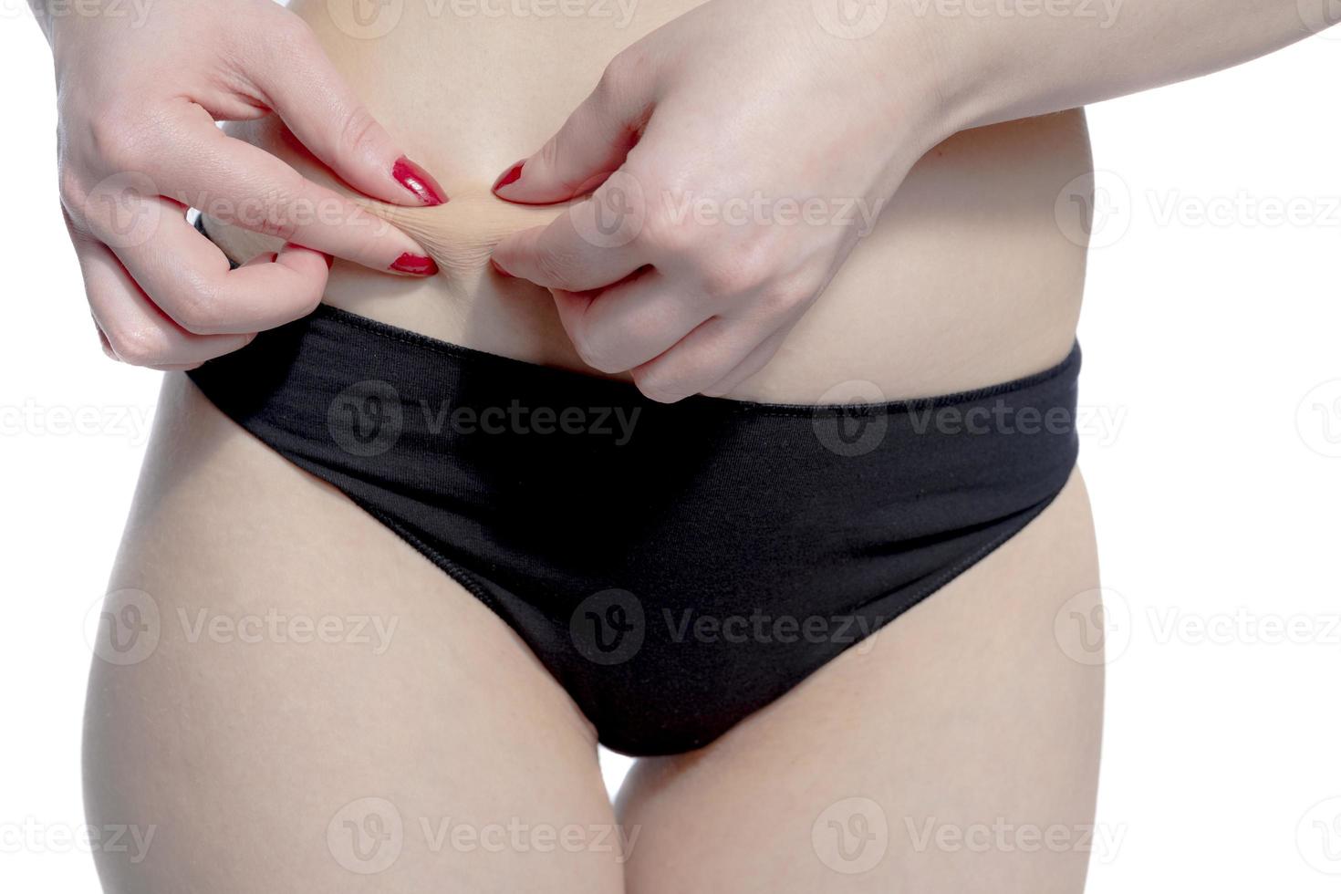 mulher beliscando a gordura da cintura foto