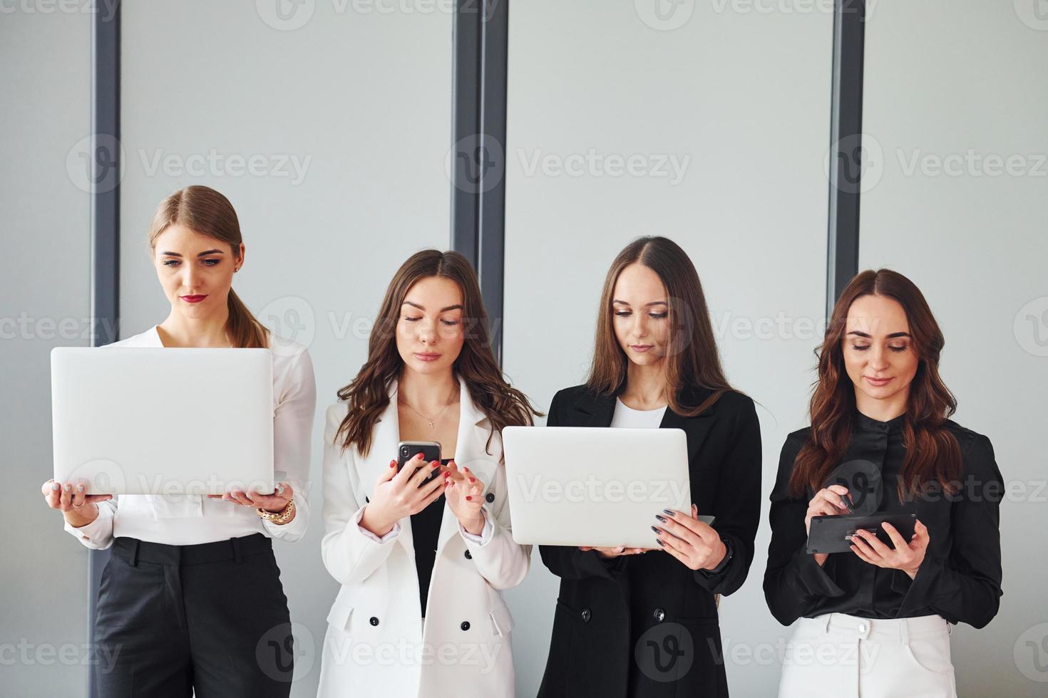 grupo de mulheres adultas que em roupas formais estão juntas no escritório foto