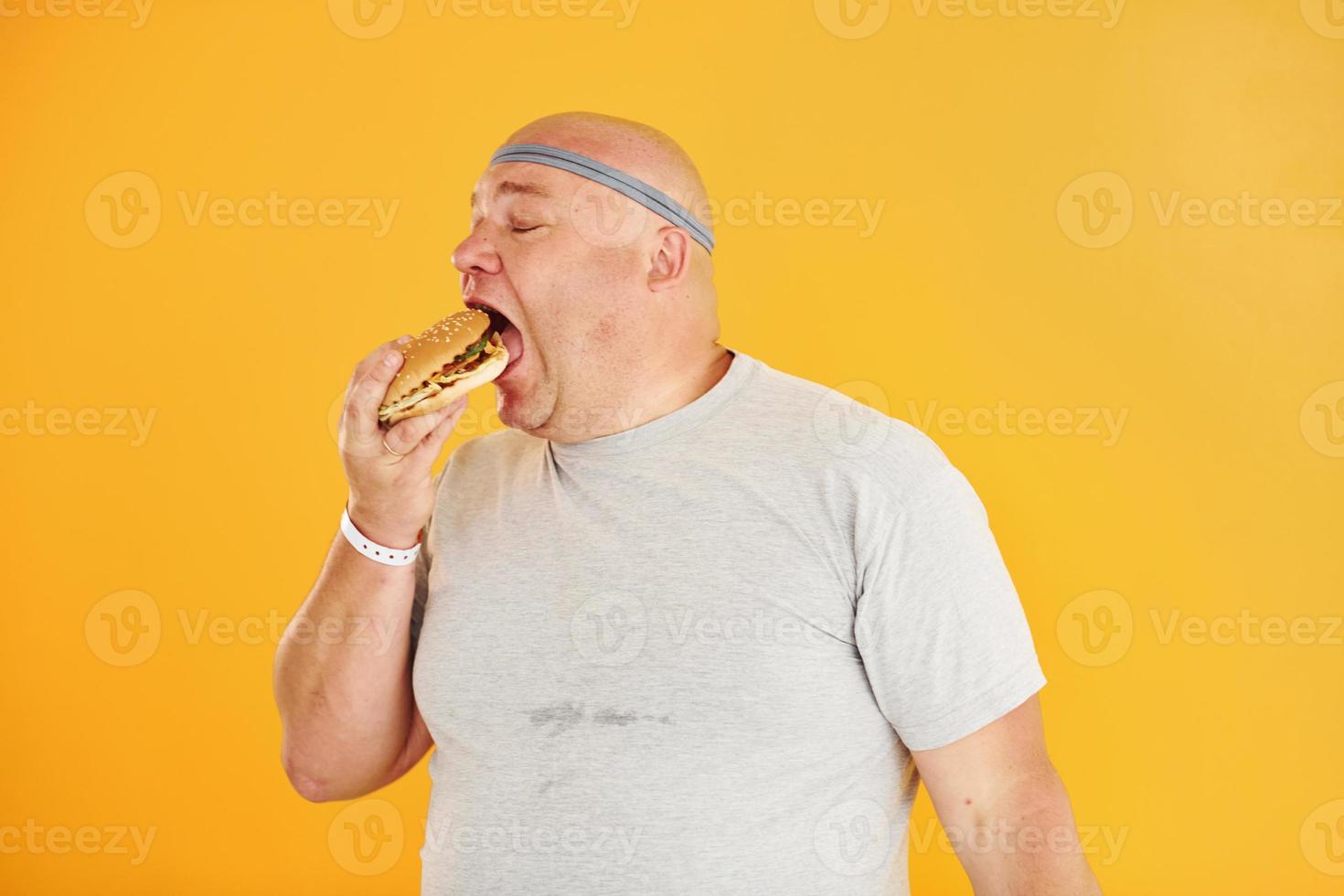 homem engraçado com excesso de peso em gravata esportiva é contra fundo amarelo foto
