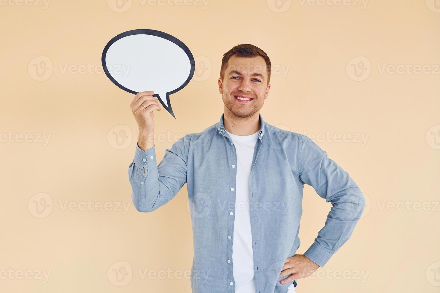 Emoções positivas. homem parado no estúdio com sinais vazios para o texto foto