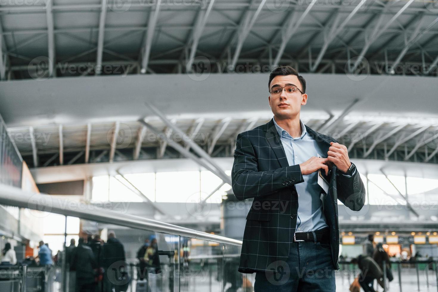 tirando os documentos. jovem empresário em roupas formais está no aeroporto durante o dia foto