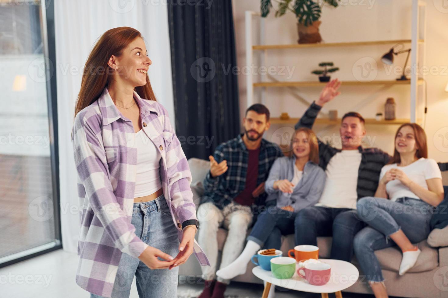 jogando o jogo com o uso de linguagem corporal e poses. grupo de amigos tem festa dentro de casa juntos foto