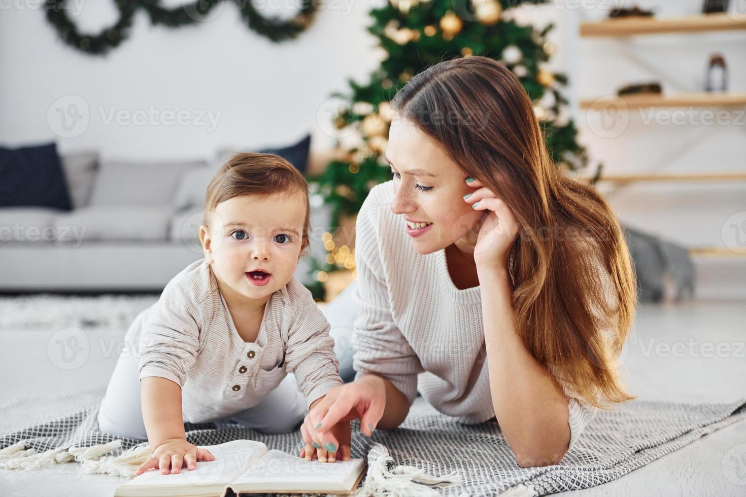 sentado no chão. mãe com sua filha está dentro de casa juntos foto