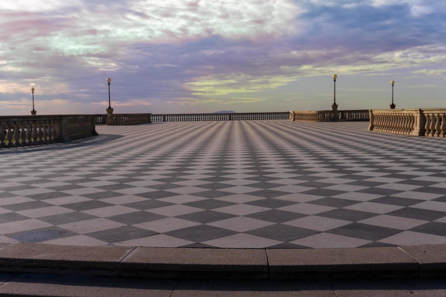 livorno, itália, 27 de novembro de 2022 - pessoas passeando no terraço mascagni, um esplêndido terraço belvedere com superfície pavimentada quadriculada, livorno, toscana, itália durante um dia ensolarado. foto