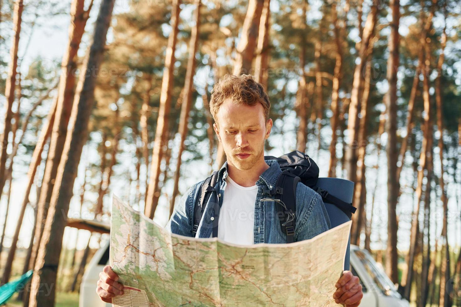 usa mapa. homem está viajando sozinho na floresta durante o dia no verão foto