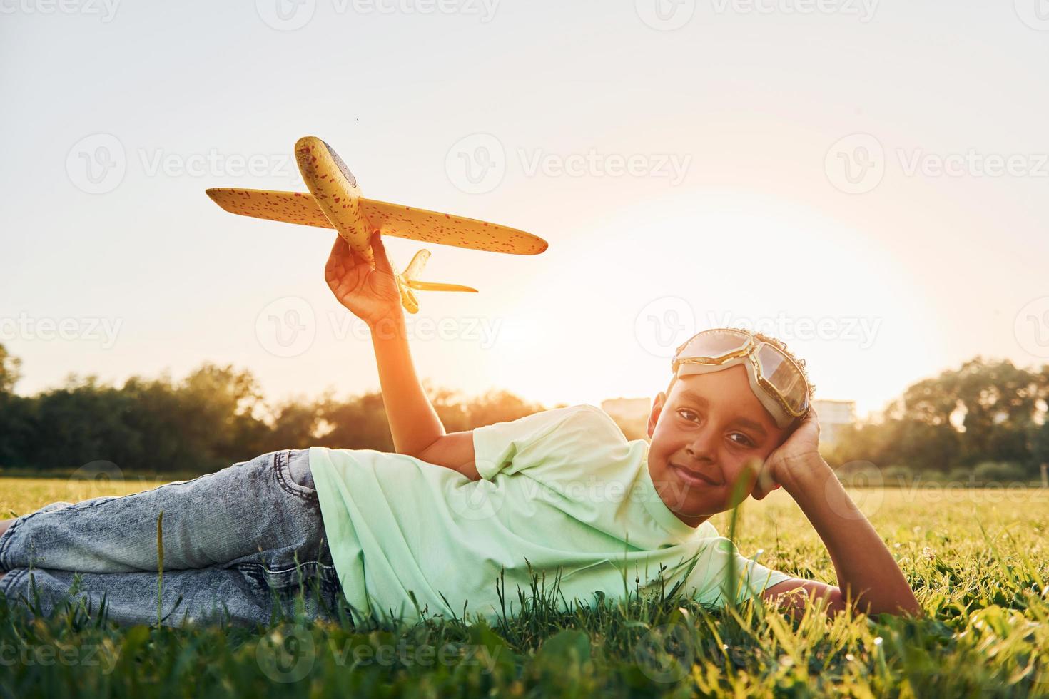 garoto afro-americano divirta-se no campo durante o dia de verão foto