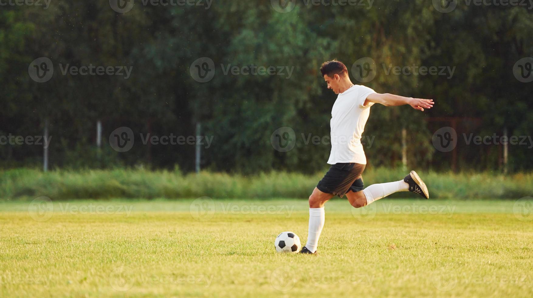 prática profissional. jovem jogador de futebol tem treinamento no campo esportivo foto