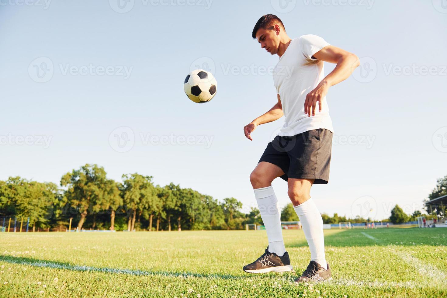 diurno de verão. jovem jogador de futebol tem treinamento no campo esportivo foto